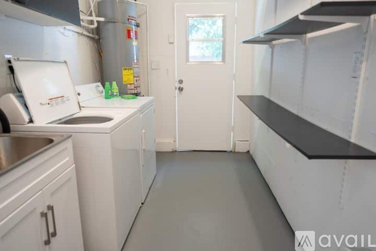A kitchen with white cabinets and a black countertop.