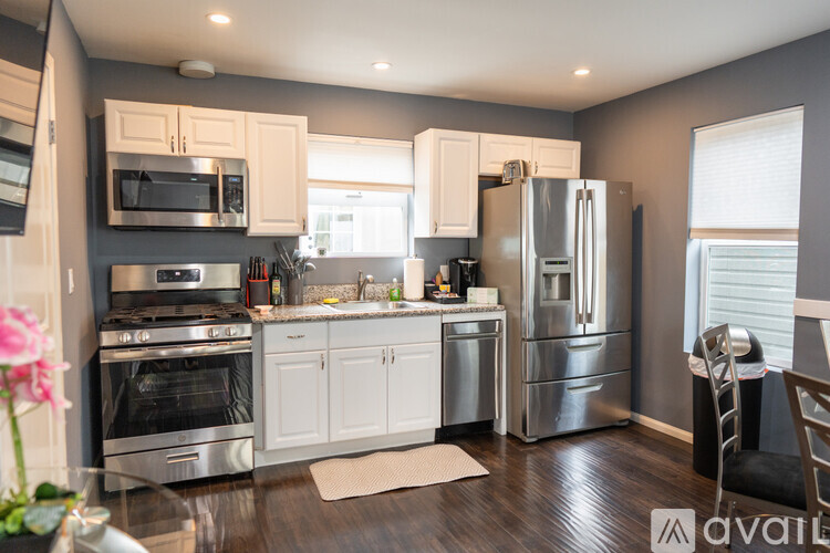A kitchen with stainless steel appliances and white cabinets.