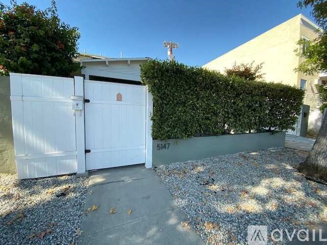 A white gate with the number 547 on it is closed.