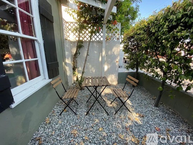 A small table and two chairs are set up on a gravel patio.