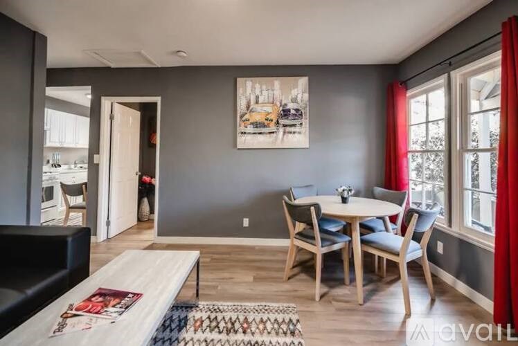 A dining room with a table set for four and a couch.