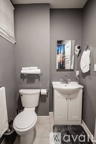 A white toilet and sink in a bathroom.