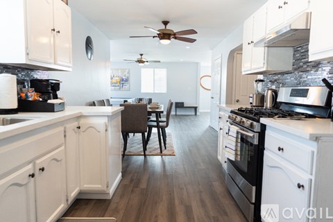 A kitchen with white cabinets and a wooden floor.
