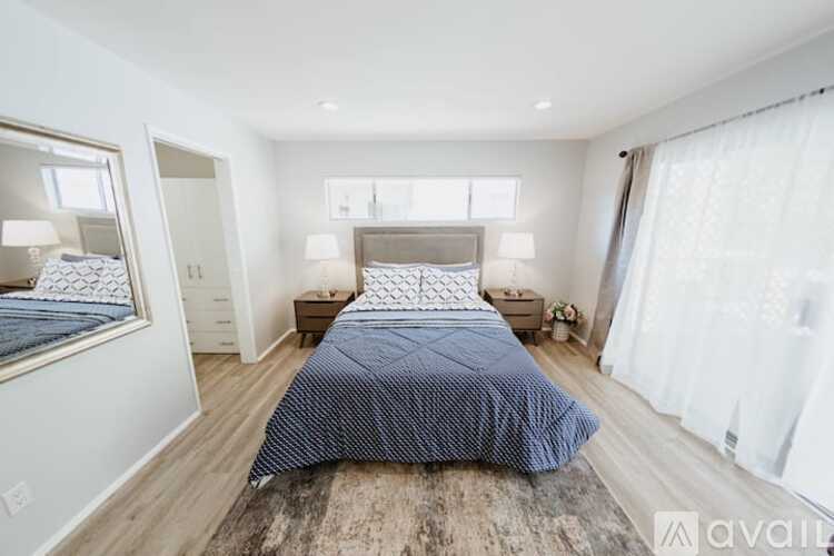 A bedroom with a large bed and a mirror on the wall.