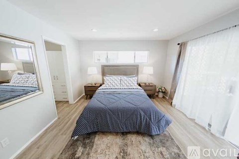 A bedroom with a large bed and a mirror on the wall.