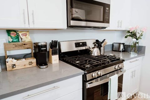 A kitchen with a black stove top and white cabinets.