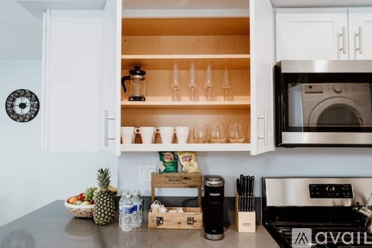 A kitchen with a black stove top and white cabinets.