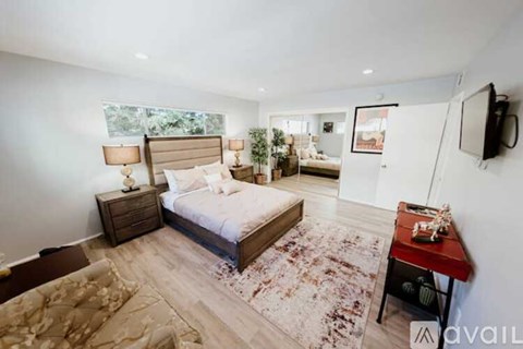 A bedroom with a large bed, a couch, and a television.