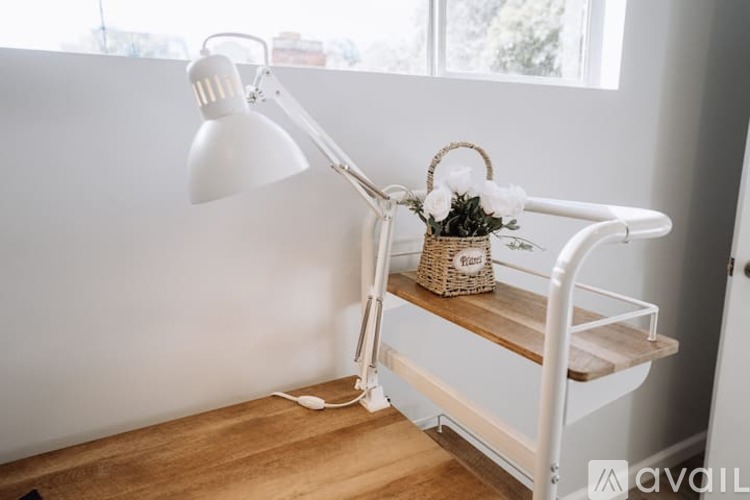 A white desk lamp with a basket of flowers on top.