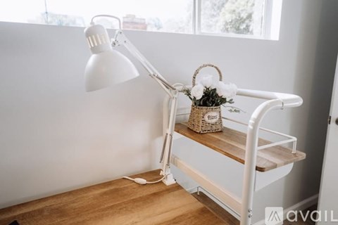 A white desk lamp with a basket of flowers on top.