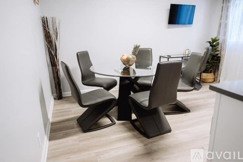 A modern dining room with a glass table and chairs.