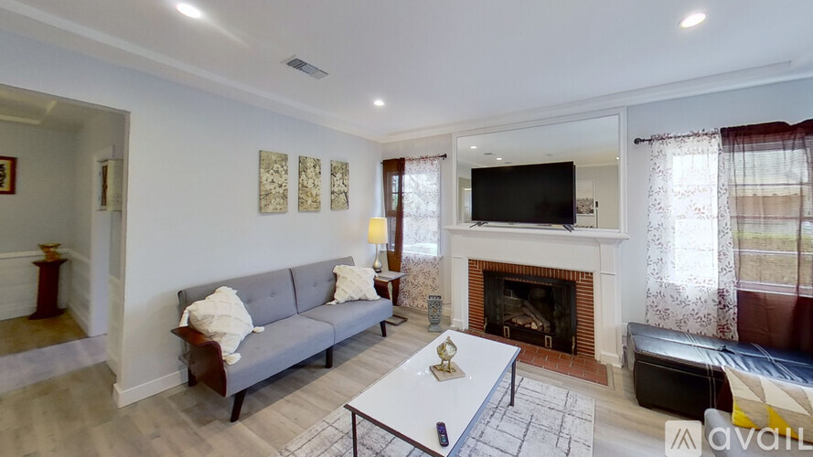 A living room with a grey couch, a coffee table, and a fireplace.
