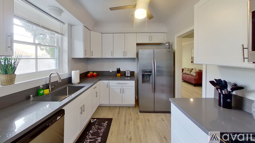 A kitchen with white cabinets and a stainless steel refrigerator.