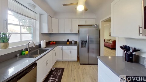 A kitchen with white cabinets and a stainless steel refrigerator.