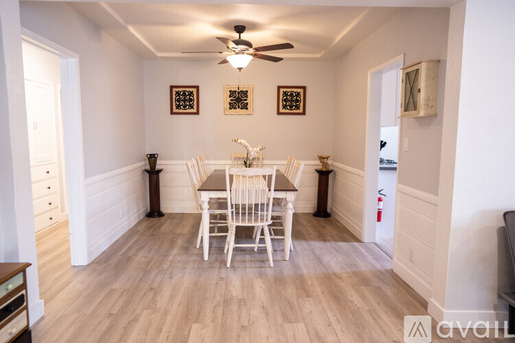 A dining room with a wooden table and chairs.