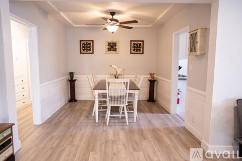 A dining room with a wooden table and chairs.