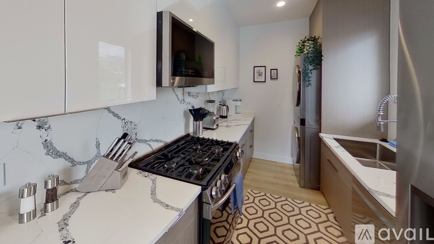 A kitchen with a marble countertop and a stove top oven.