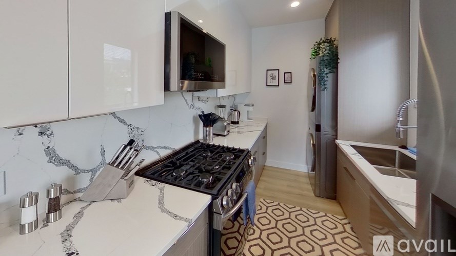 A kitchen with a marble countertop and a stove top oven.