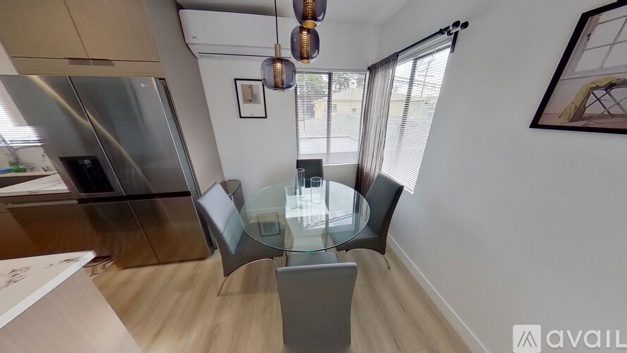 A modern kitchen with a glass table and chairs.