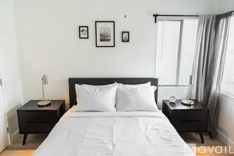 A bedroom with a large bed and two nightstands with lamps.