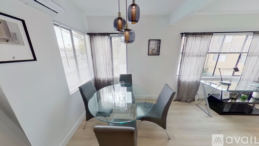 A modern dining room with a glass table and chairs.