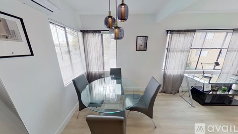 A modern dining room with a glass table and chairs.