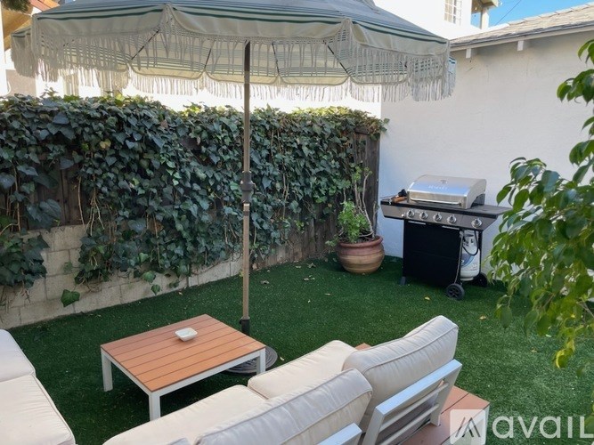 A patio with a table, chairs, and an umbrella.