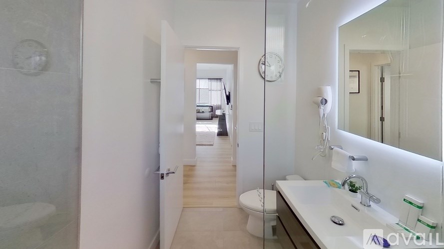 A bathroom with a toilet, sink, and mirror.