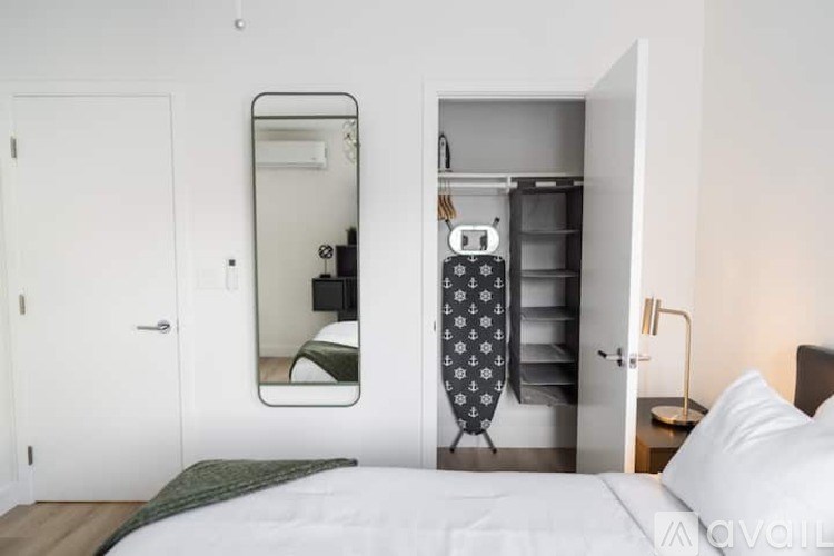 A bedroom with a bed, a mirror, a wardrobe, and a nightstand.