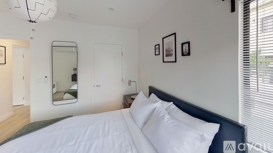 A bedroom with a large bed and a mirror on the wall.