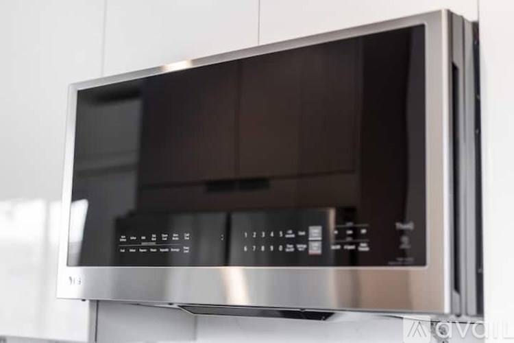 A modern stainless steel microwave oven with a digital display.