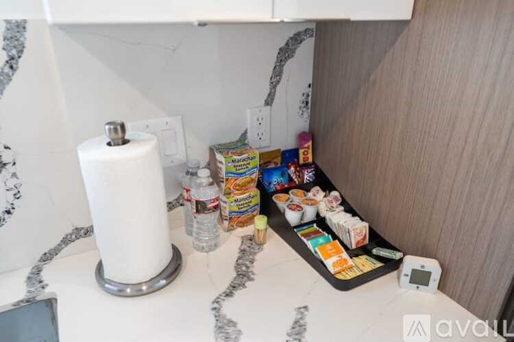 A kitchen counter with a toaster, a bottle of water, and a box of cereal.