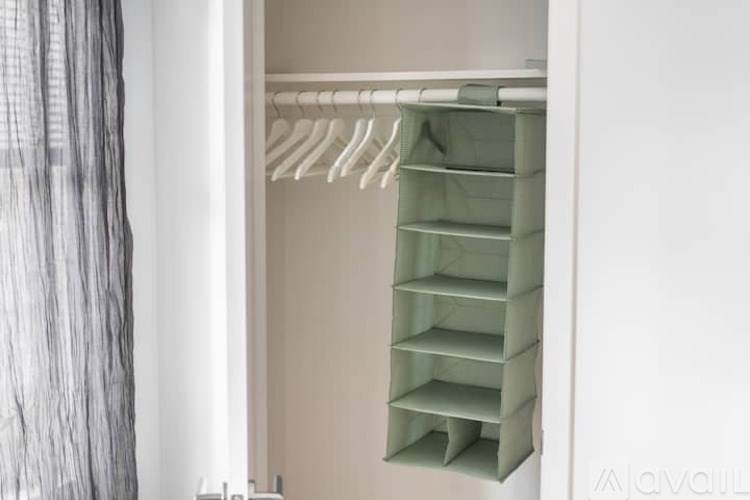 A white closet with a hanging rod and shelves.