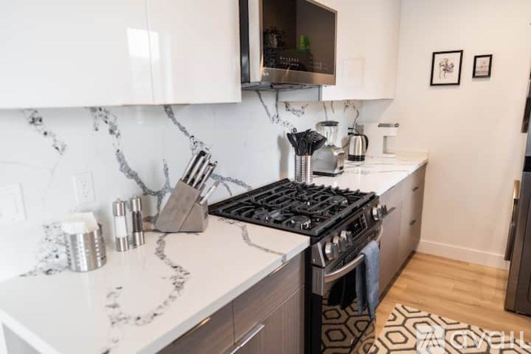A kitchen with a white counter top and a black stove.