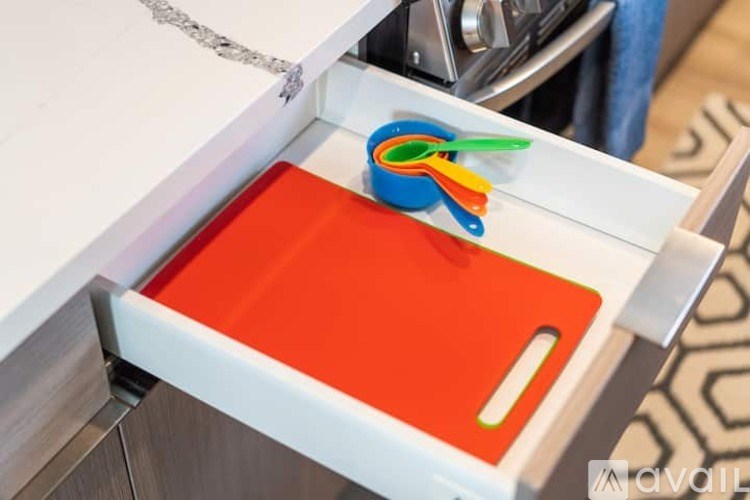 A pair of scissors is placed on a red cutting board.