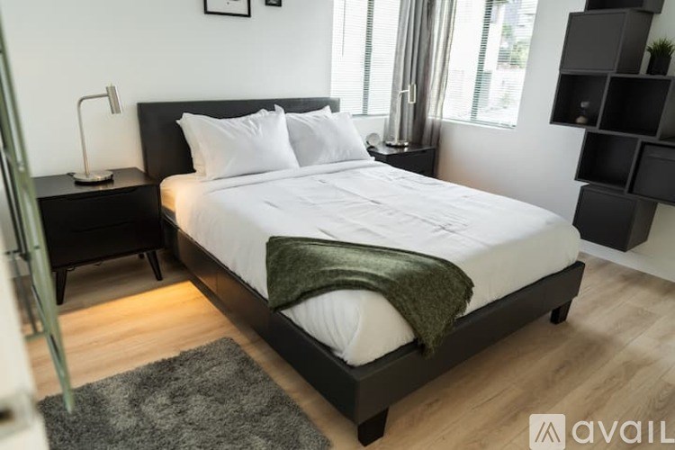 A bedroom with a large bed and a green blanket.