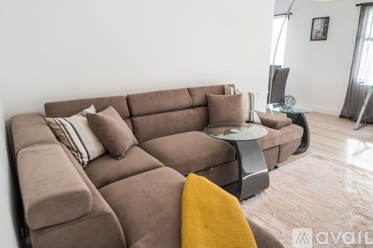 A brown sectional sofa with a yellow throw pillow on it.