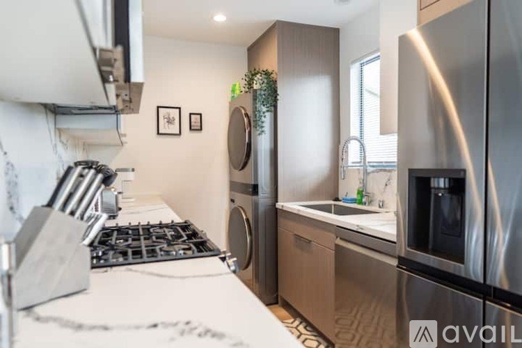 A modern kitchen with stainless steel appliances and a white countertop.