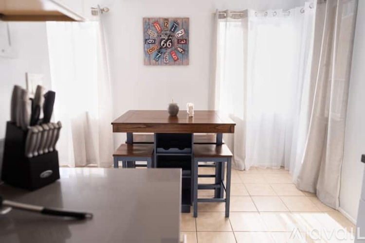 A dining room with a table and chairs.