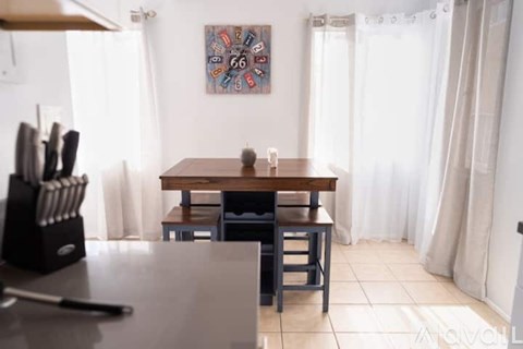 A dining room with a table and chairs.