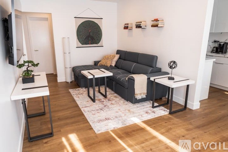 A living room with a grey couch, a small table, and a plant.