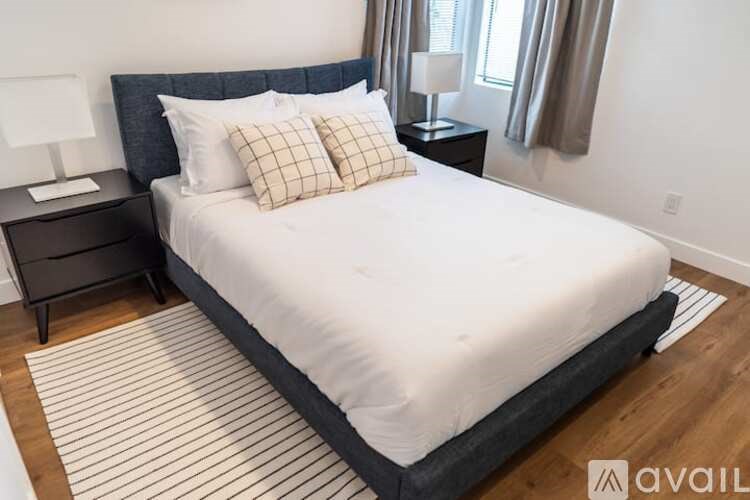 A bed with a white comforter and two pillows is in the image.
