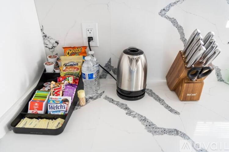 A kitchen counter with a tray of snacks, a kettle, and a bottle of water.