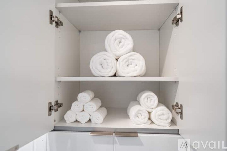 A white cabinet with towels on the shelves.