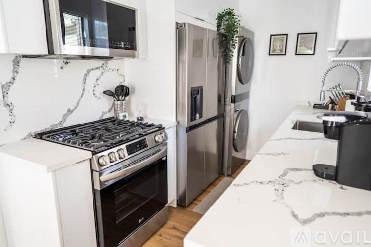 A modern kitchen with a stove, refrigerator, and microwave.