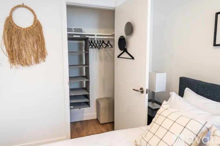 A bedroom with a bed, a wardrobe, and a mirror.