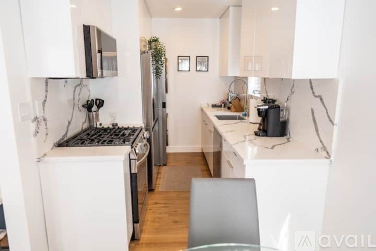 A modern kitchen with white appliances and cabinets.