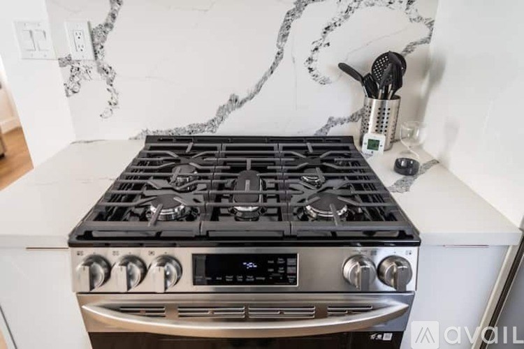 A stainless steel oven with a digital display and four burners.