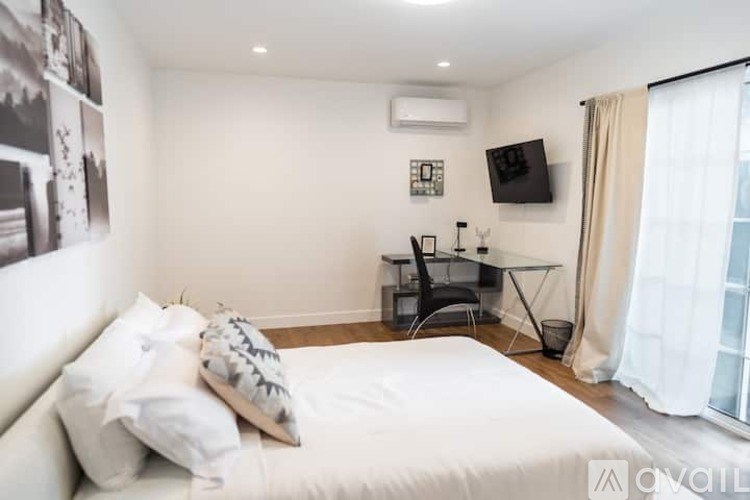 A bedroom with a bed, desk, and chair.