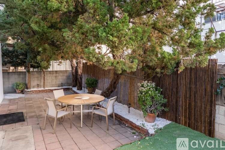 A patio with a table and chairs surrounded by a wooden fence.